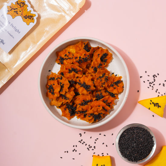 Pumpkin crackers with black seeds on a pink background