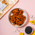 Pumpkin crackers with black seeds on a pink background