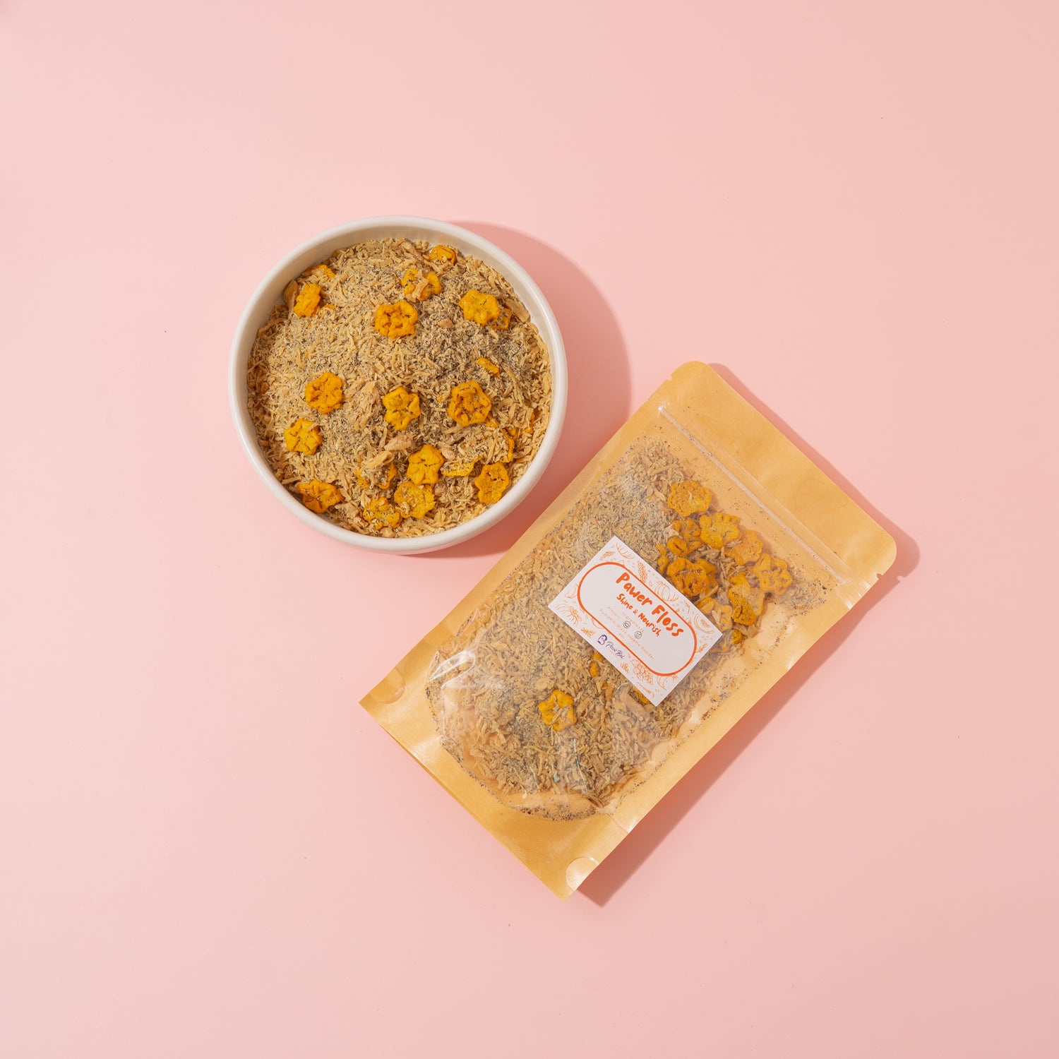 Dried flowers in a bowl and packaging on a pink background