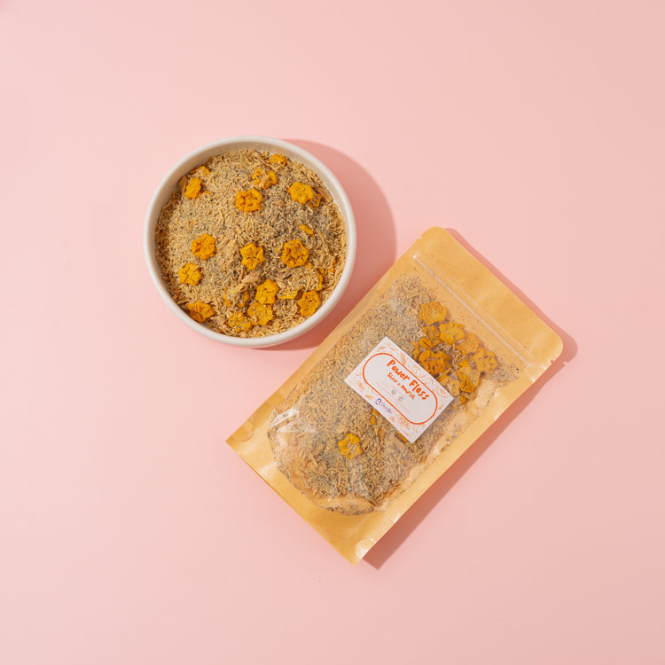 Dried flowers in a bowl and packaging on a pink background